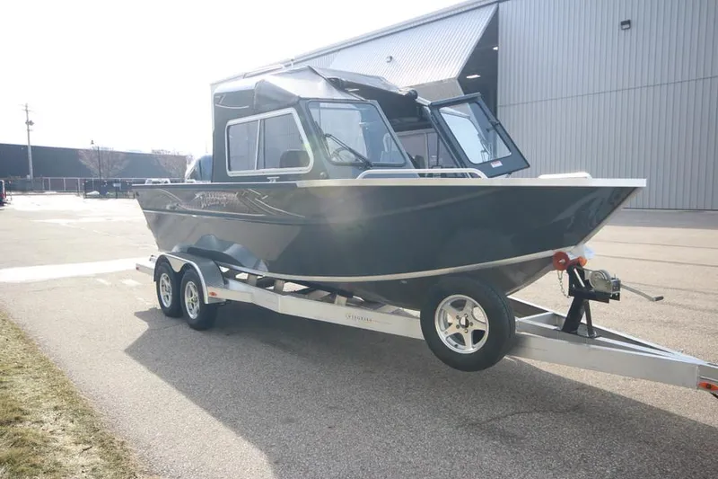 Slide: The Image of 2023 Weldcraft 210 Revolution F200XB boat on a trailer outside a warehouse. - 16