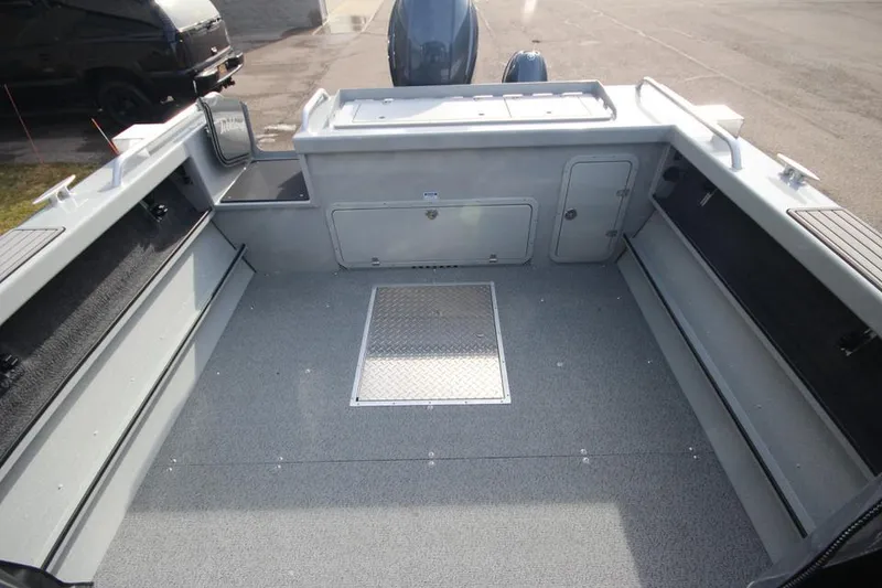 Slide: The Image of 2023 Weldcraft 210 Revolution F200XB boat interior, spacious deck with storage compartments. - 21