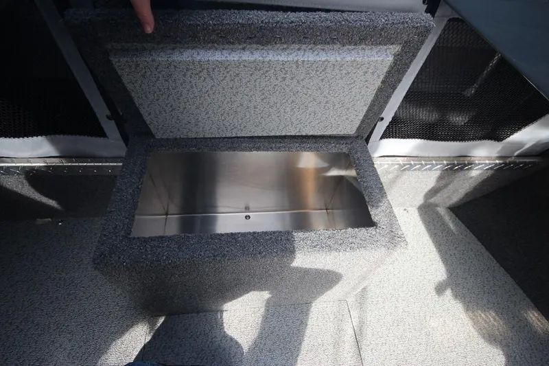 Slide: The Image of 2023 Weldcraft 210 Revolution F200XB storage compartment with open lid. - 27