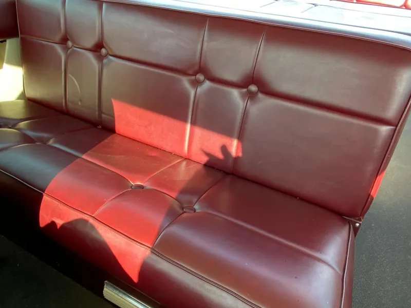 Slide: The Image of 1968 Century Coronado maroon leather interior with tufted seating and sunlight shadow. - 11