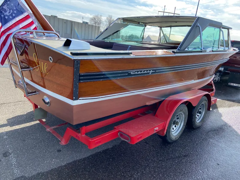 Slide: The Image of 1968 Century Coronado boat on red trailer, featuring classic wooden design and American flag. - 3