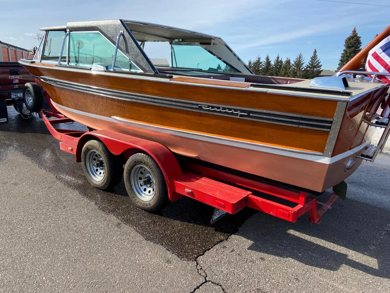 Slide: The Image of 1968 Century Coronado boat on red trailer, showcasing classic wooden design and chrome accents. - 5