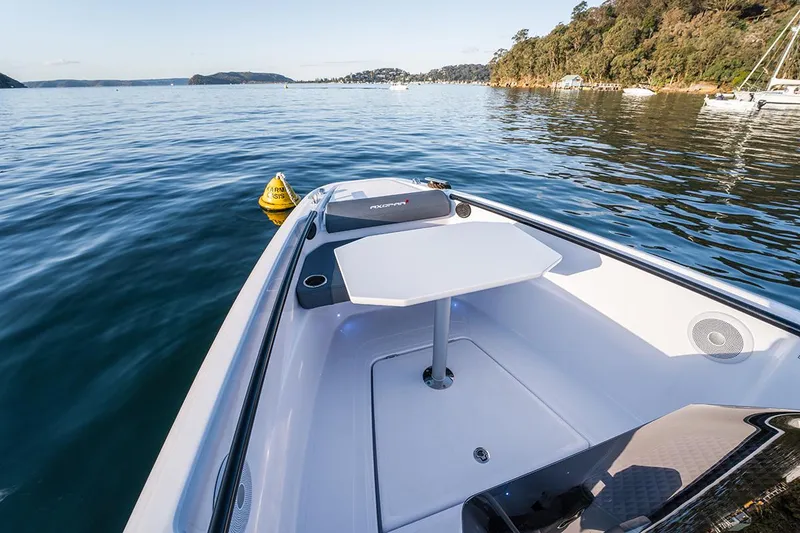 Slide: The Image of 2022 Axopar 22 T-Top boat on calm water with scenic background. - 12