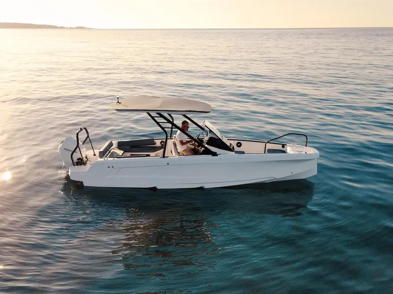 Slide: The Image of 2022 Axopar 22 T-Top boat cruising on calm waters at sunset. - 15