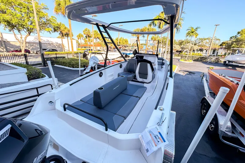 Slide: The Image of 2022 Axopar 22 T-Top boat with sleek design, parked outdoors under clear blue sky. - 3