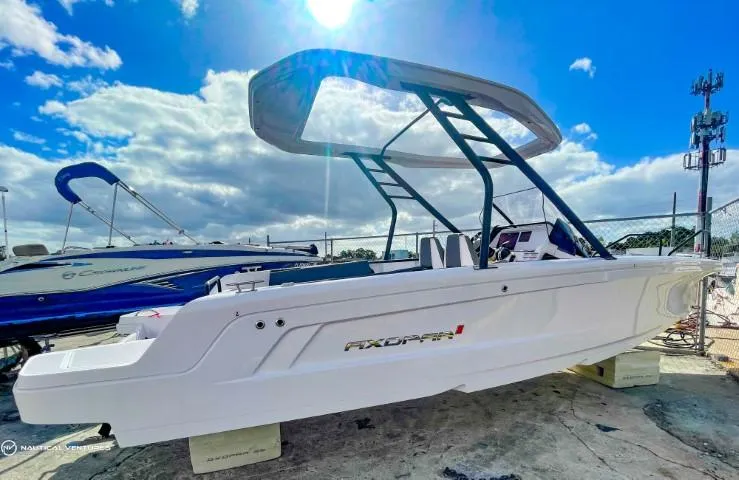 Slide: The Image of 2022 Axopar 22 T-Top boat displayed outdoors under a bright sky. - 5