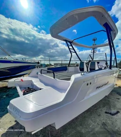Slide: The Image of 2022 Axopar 22 T-Top boat with sleek design, docked under a partly cloudy sky. - 6