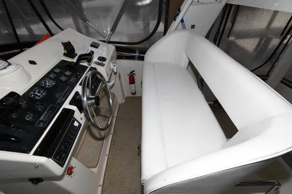 Slide: The Image of Helm station of 1995 Silverton 34 Aft Cabin Motor Yacht with white seating. - 10