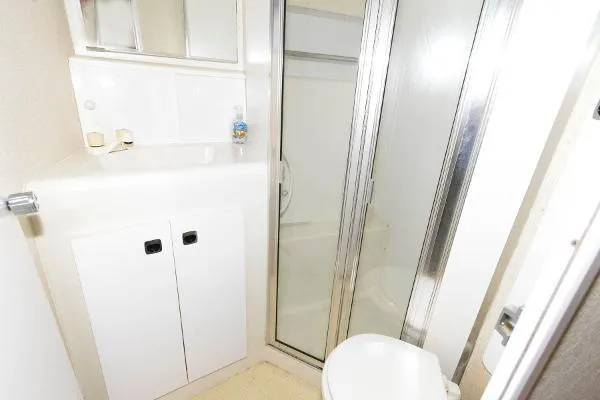 Slide: The Image of Bathroom of 1995 Silverton 34 Aft Cabin Motor Yacht with shower, sink, and storage cabinets. - 23