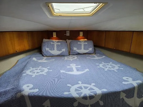 Slide: The Image of 1995 Silverton 34 Aft Cabin Motor Yacht bedroom with nautical-themed bedding. - 24