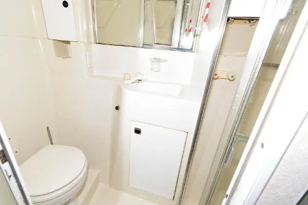 Slide: The Image of 1995 Silverton 34 Aft Cabin Motor Yacht bathroom with toilet, sink, and mirror. - 25