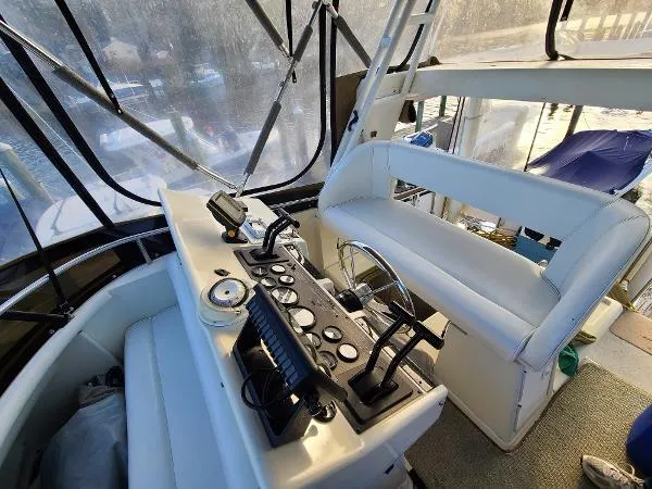 Slide: The Image of 1995 Silverton 34 Aft Cabin Motor Yacht helm station with controls and seating. - 9