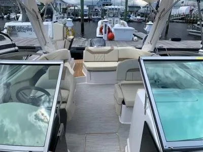 Slide: The Image of 2019 Regal 23obx boat interior with beige seating at a marina. - 1