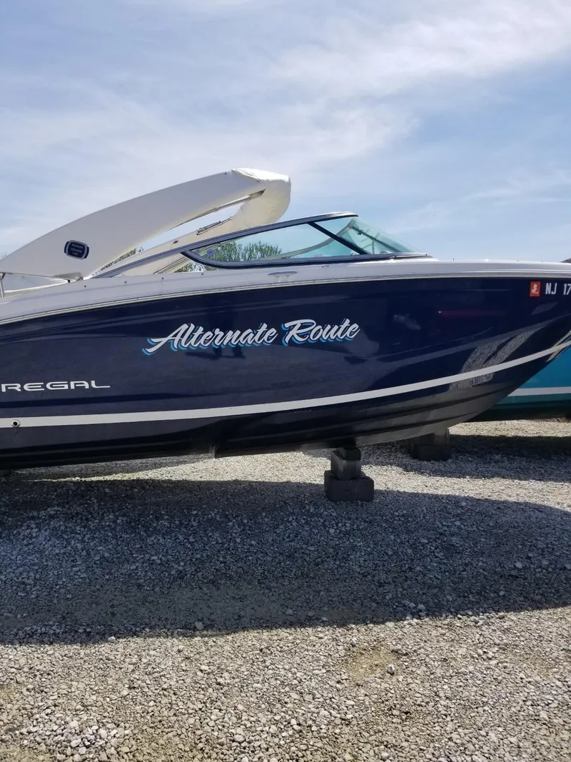 Slide: The Image of 2019 Regal 23obx boat named "Alternate Route" on gravel, side view. - 13