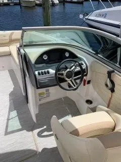 Slide: The Image of 2019 Regal 23obx boat cockpit with steering wheel and dashboard, docked at marina. - 2