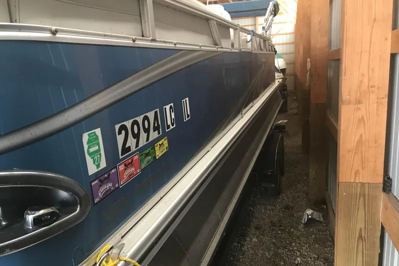 Slide: The Image of 2022 Avalon VENTURE QUAD LOUNGE boat stored in a wooden shed. - 15