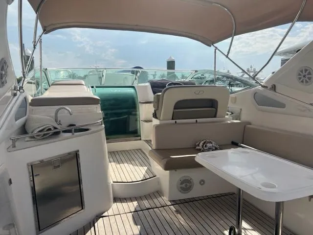 Slide: The Image of 2018 Schaefer 365 yacht interior with seating, table, and canopy under sunny skies. - 23