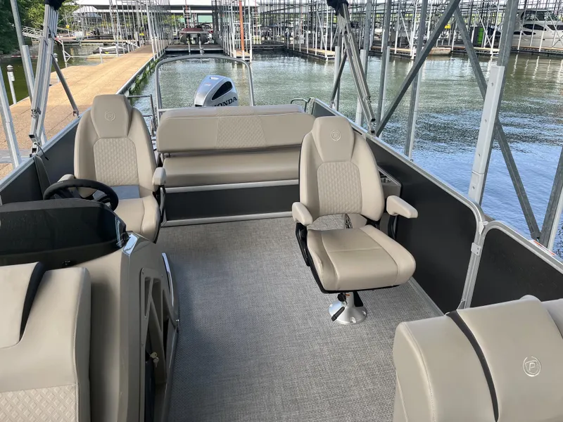 Slide: The Image of 2022 Premier 250 SunSation RL pontoon boat interior with beige seating and helm. - 5