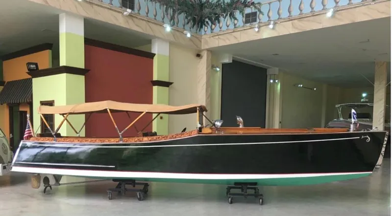 Slide: The Image of Custom 2004 28 Rum Runner Richard Speas boat with tan canopy in indoor showroom. - 4