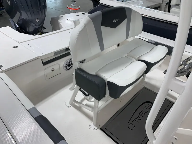Slide: The Image of 2024 Robalo 246 Cayman boat interior with cushioned seating and storage. - 13