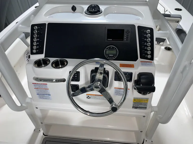 Slide: The Image of 2024 Robalo 246 Cayman boat dashboard with steering wheel and control panel. - 3