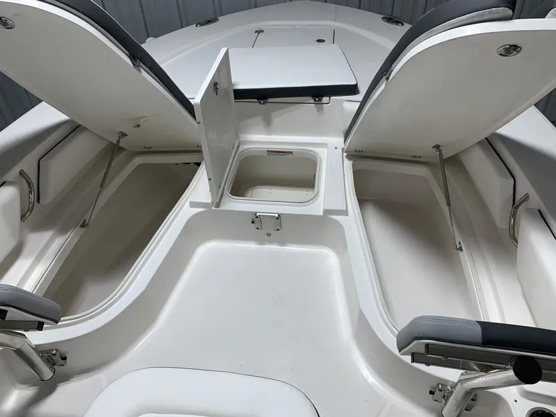 Slide: The Image of 2024 Robalo 246 Cayman boat storage compartments and seating area. - 9