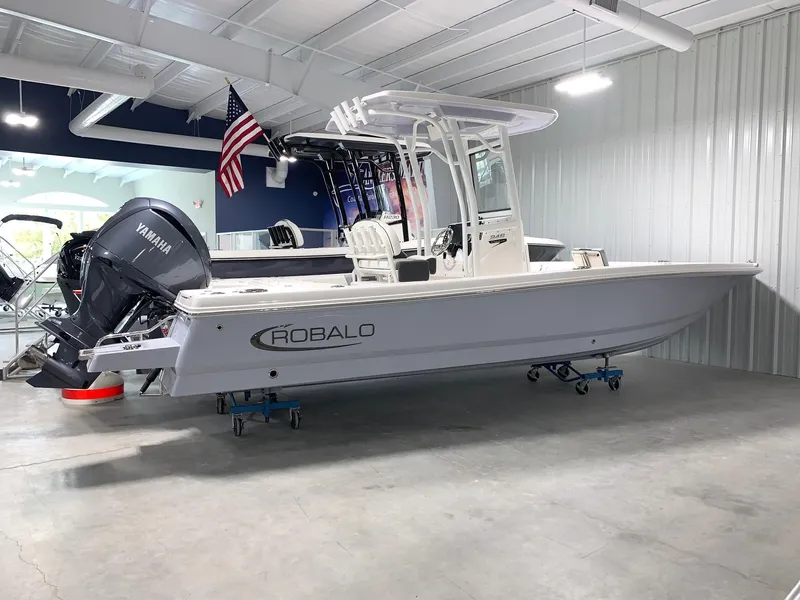 Slide: The Image of 2024 Robalo 246 Cayman boat in showroom with Yamaha outboard motor. - 2