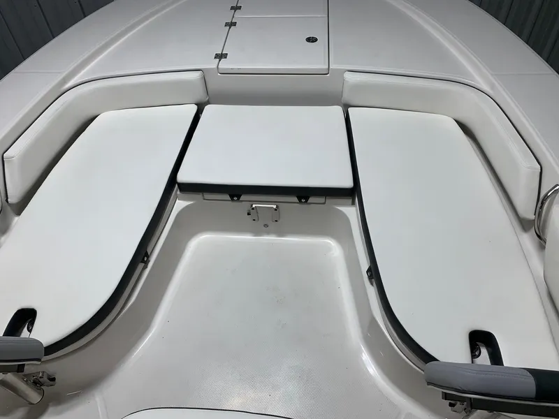 Slide: The Image of 2024 Robalo 246 Cayman boat with white cushioned seating and storage compartments. - 8