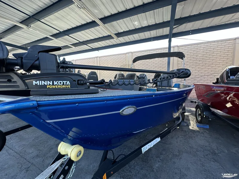 Slide: The Image of 2022 Lund 1650 Angler SS boat with Minn Kota PowerDrive motor, under a metal canopy. - 5