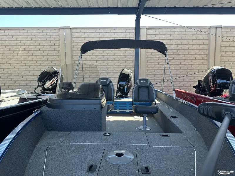 Slide: The Image of 2022 Lund 1650 Angler SS fishing boat with Mercury outboard engines, under a covered area. - 7