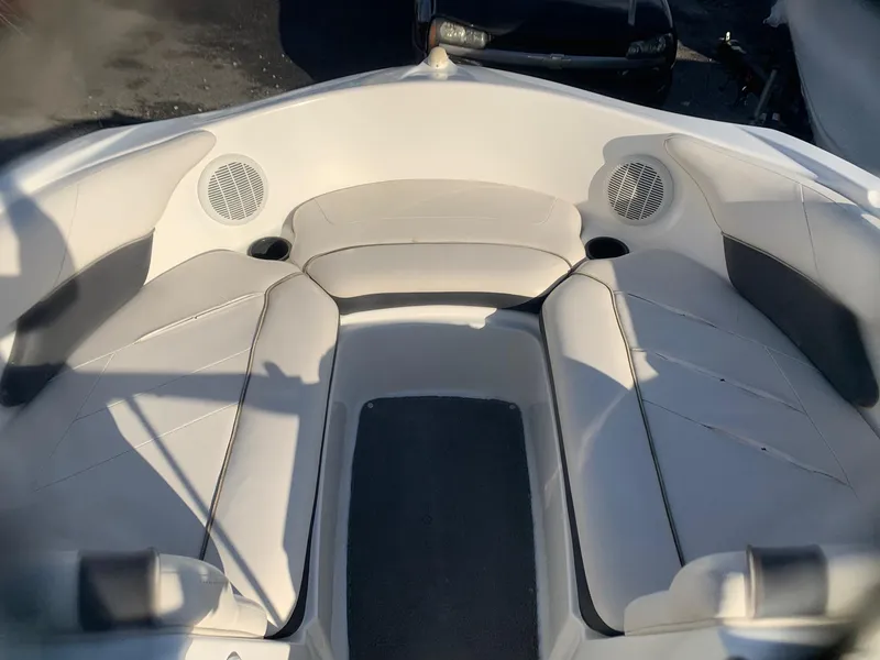 Slide: The Image of 2012 Yamaha Boats SX190 bow seating area with white and gray upholstery. - 2