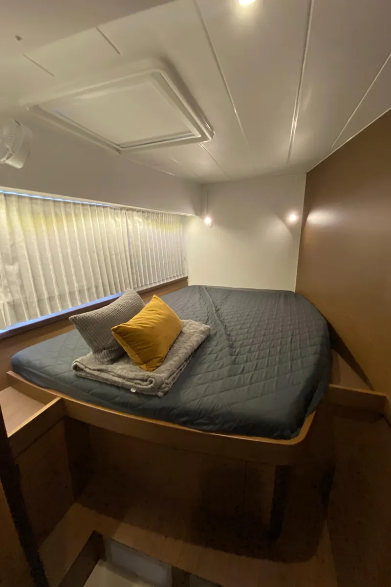 Slide: The Image of Cozy cabin interior of 2022 Lagoon 42 catamaran with bed and cushions. - 14