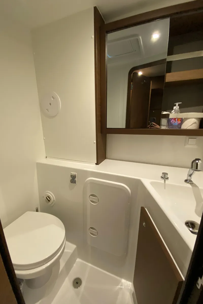 Slide: The Image of Modern bathroom in 2022 Lagoon 42 yacht with toilet, sink, and mirror cabinet. - 17