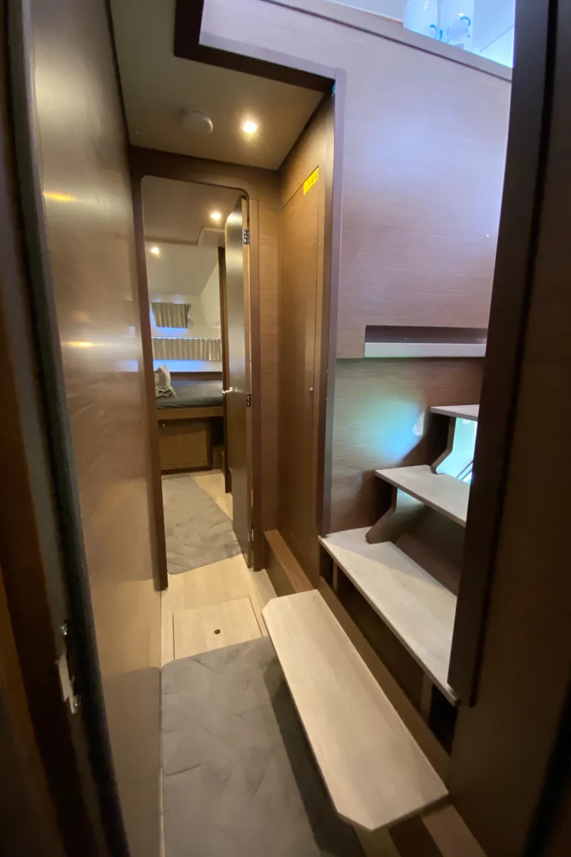 Slide: The Image of Interior of 2022 Lagoon 42 yacht, featuring wooden stairs and modern design. - 18