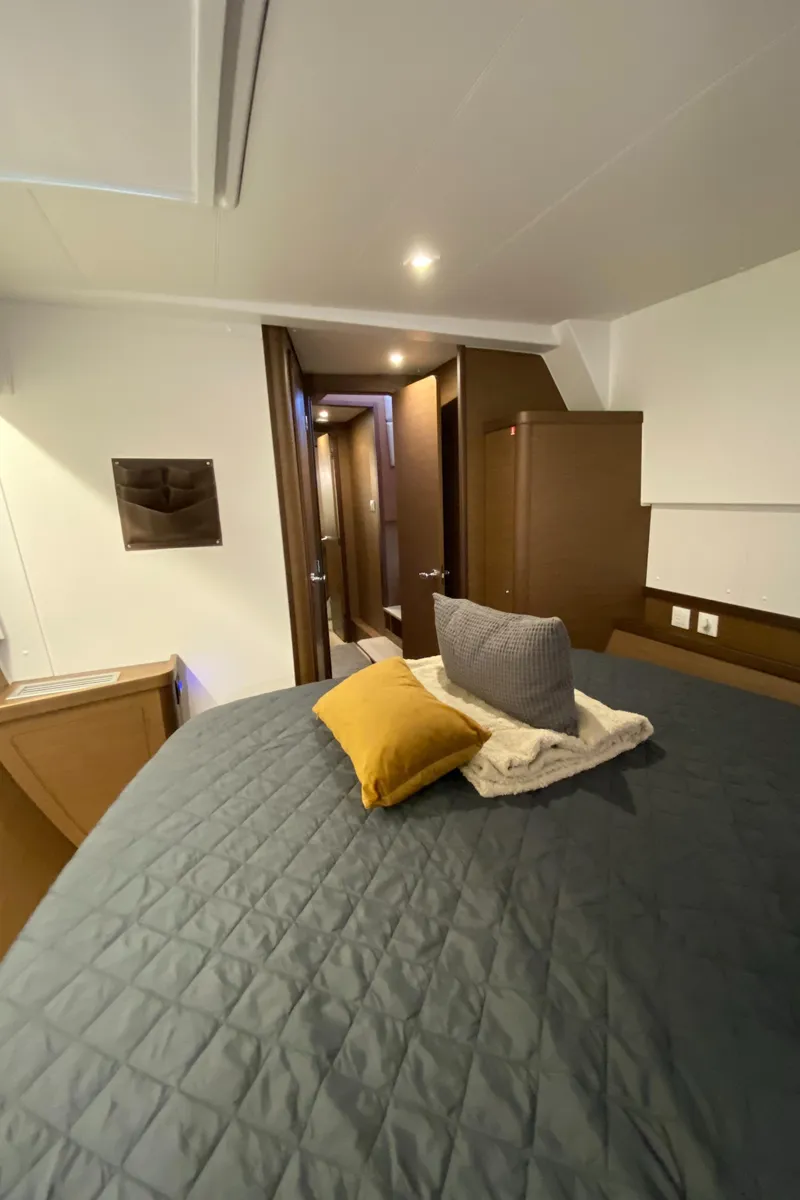 Slide: The Image of Interior of 2022 Lagoon 42 yacht cabin with cozy bedding and modern design. - 22