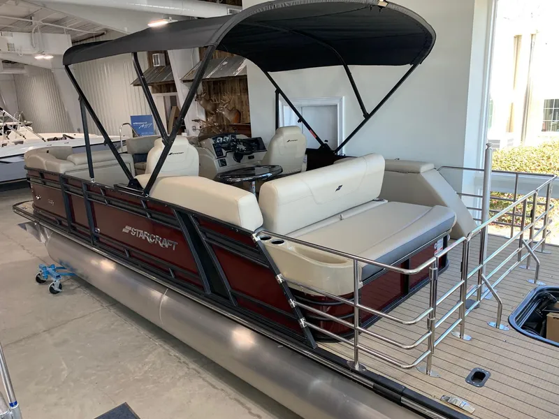 Slide: The Image of 2024 Starcraft SLS 3 Q DH pontoon boat with beige seating and black canopy. - 1