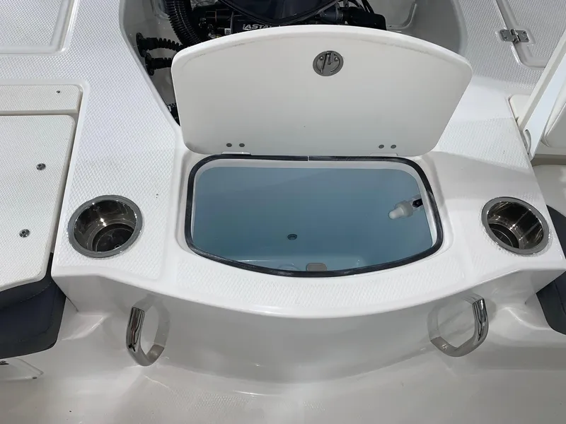 Slide: The Image of 2024 Robalo 206 Cayman boat with open storage compartment and cup holders. - 13