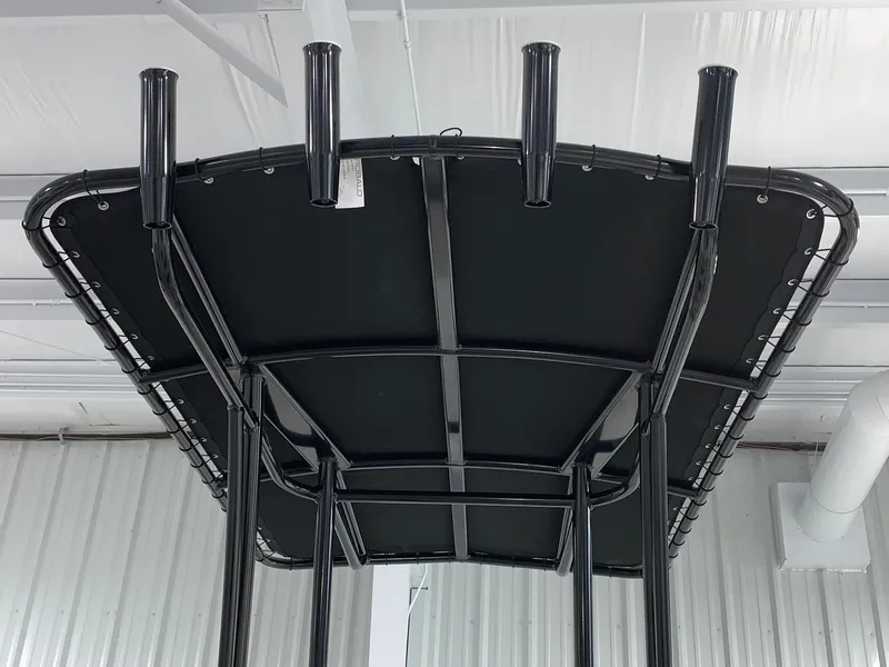 Slide: The Image of 2024 Robalo 206 Cayman T-top with rod holders in a showroom. - 2