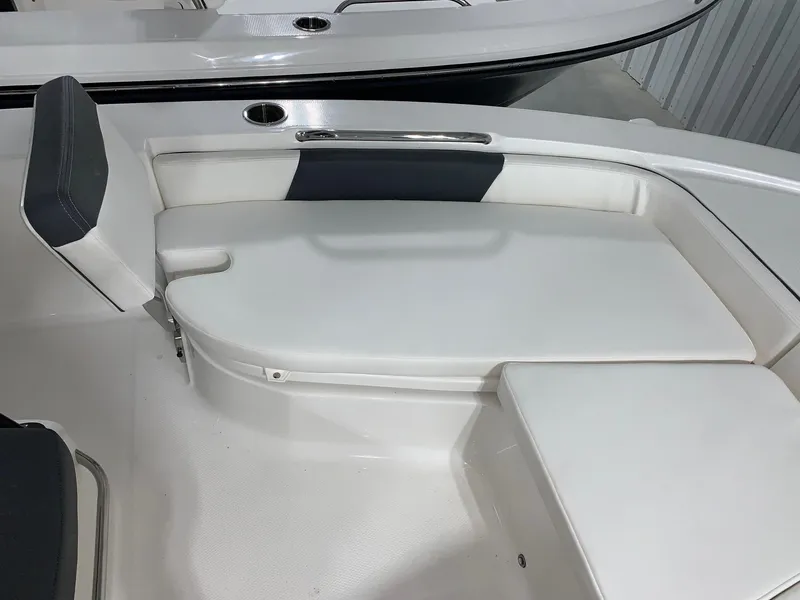 Slide: The Image of 2024 Robalo 206 Cayman boat interior seating with white and black cushions. - 10