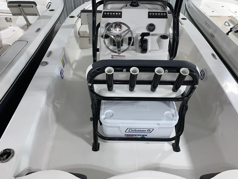 Slide: The Image of 2024 Robalo 206 Cayman boat interior with steering console and rod holders. - 2