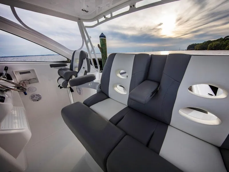 Slide: The Image of 2025 Albemarle 31DC boat interior with gray and white seating, helm station, and scenic water view. - 22