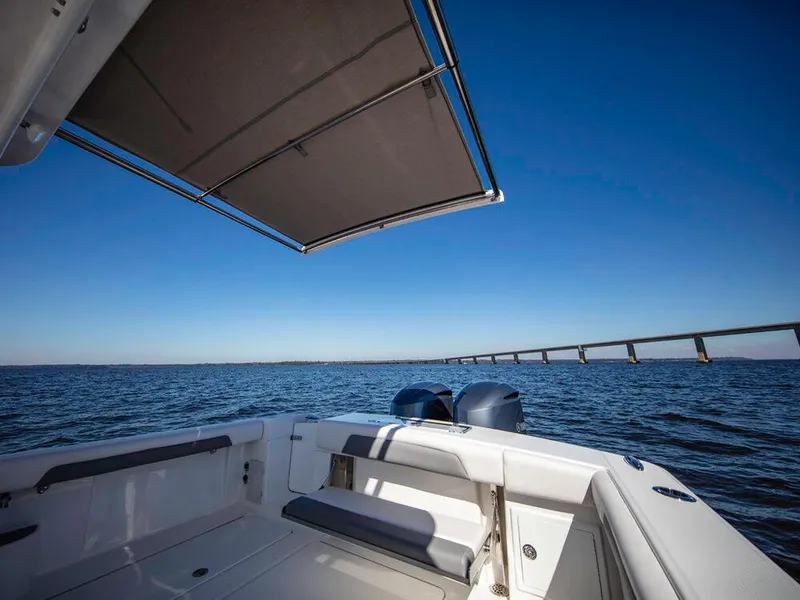 Slide: The Image of 2025 Albemarle 31DC boat with canopy, ocean view, and distant bridge. - 3