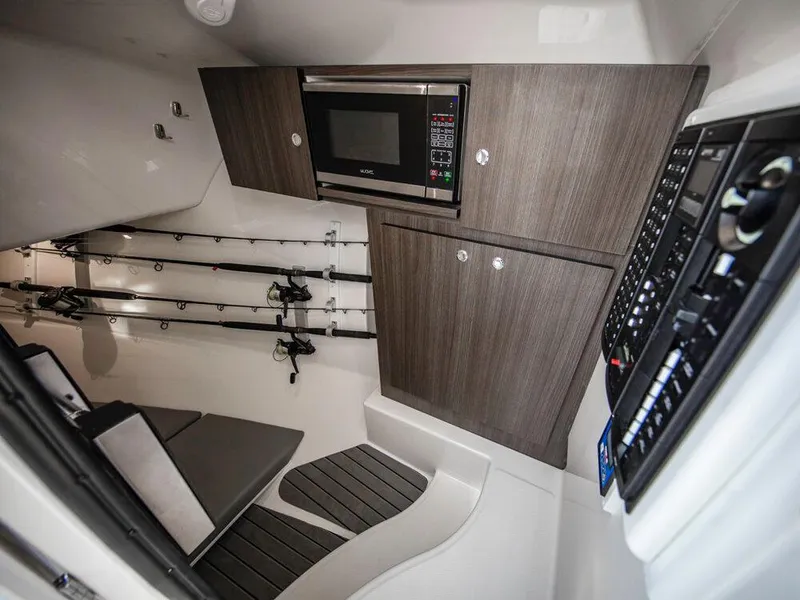 Slide: The Image of Interior of 2025 Albemarle 31DC boat with microwave, cabinets, and fishing rod storage. - 31