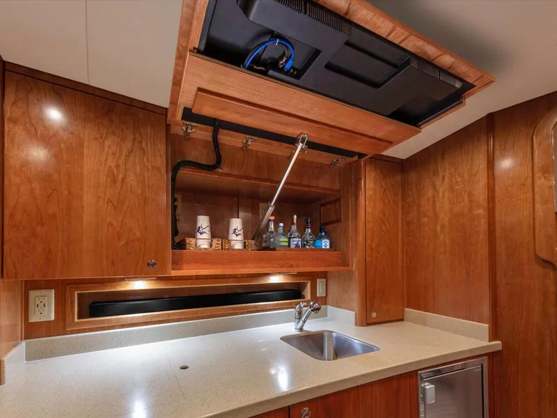 Slide: The Image of 2025 Albemarle 410 Express Fisherman yacht kitchen with wooden cabinets and hidden storage. - 9