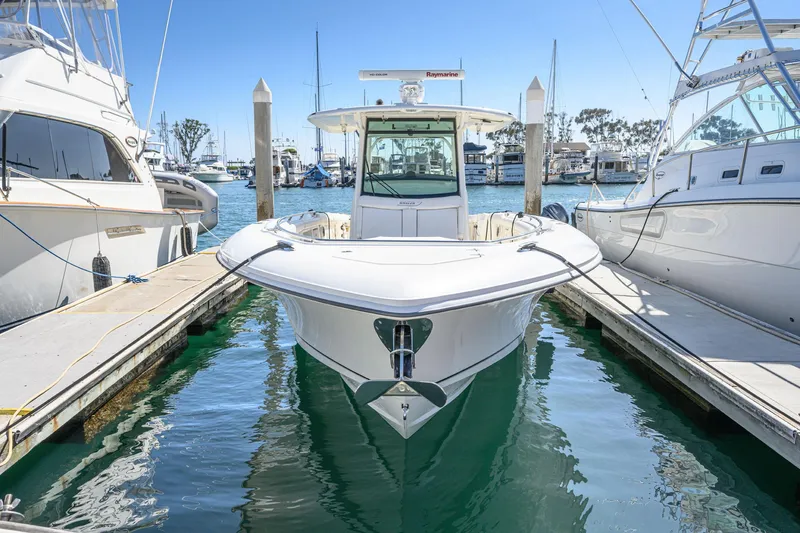 Slide: The Image of 2016 Boston Whaler 350 Outrage docked between two boats. - 7
