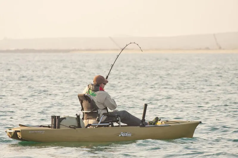 Slide: The Image of Angler fishing from a 2023 Hobie Pro Angler 12 kayak on a calm sea. - 9
