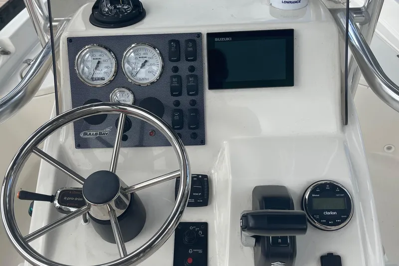 Slide: The Image of 2021 Bulls Bay 2000 boat dashboard with steering wheel, gauges, and navigation controls. - 5