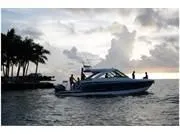 Slide: The Image of 2024 Formula 380 Super Sport Crossover boat cruising at sunset near palm trees. - 10
