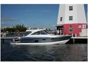 Slide: The Image of 2024 Formula 380 Super Sport Crossover yacht docked near a lighthouse. - 6