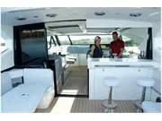 Slide: The Image of 2024 Formula 500 Super Sport Crossover yacht interior with modern seating and bar area. - 24